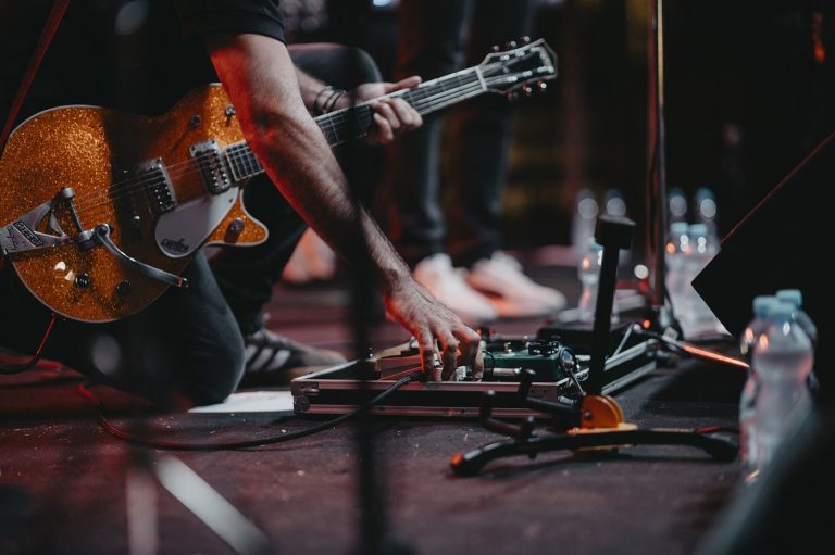 A musician performing on stage under concert lights